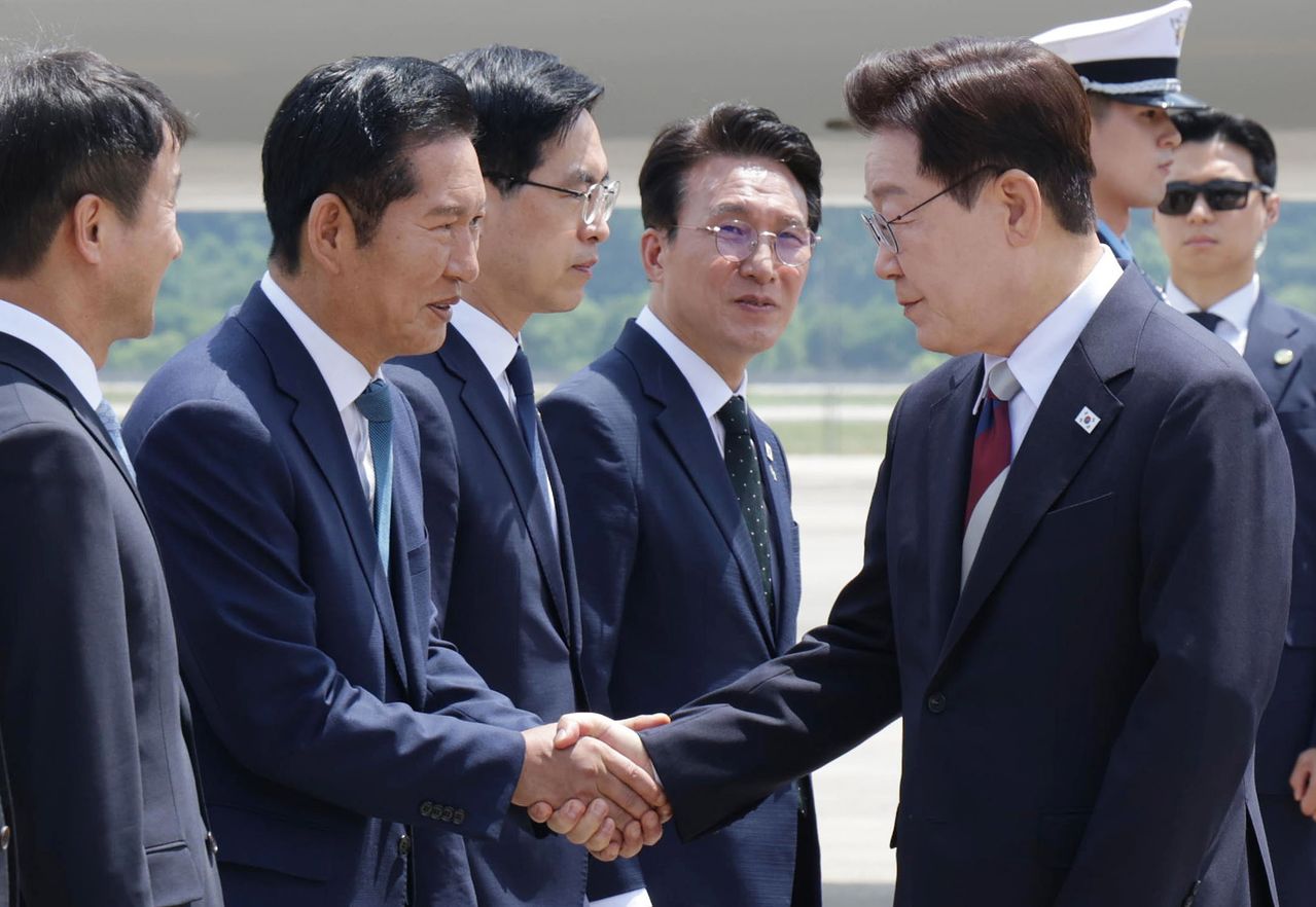 주요 7개국(G7) 정상회의 일정을 마친 이재명 대통령이 18일 경기 성남 서울공항에 도착해 정청래 더불어민주당 대표와 인사를 나누고 있다. 청와대사진기자단