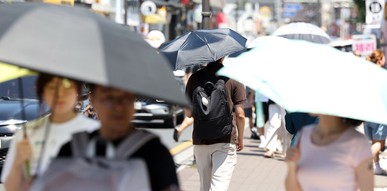 2일 경북 경주시에 폭염 중대경보가 내려진 가운데 황리단길에서 관광객들이 양산을 쓰고 걷고 있다. 연합뉴스 