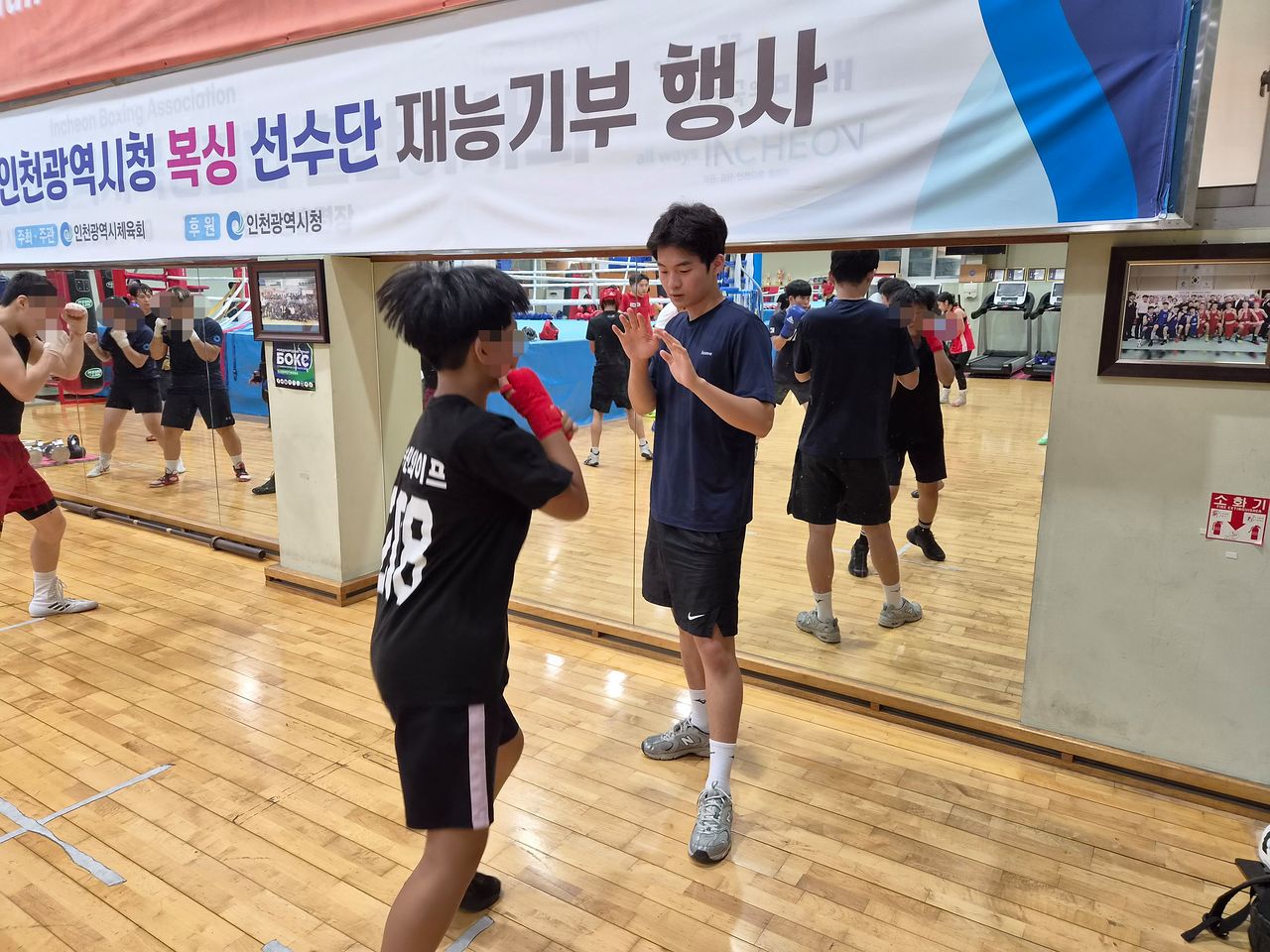 인천 미추홀경찰서 폴 인 스포츠 프로젝트에 참여한 청소년이 박단비 코치에게 잽을 배우고 있다. 사진 변민철 기자