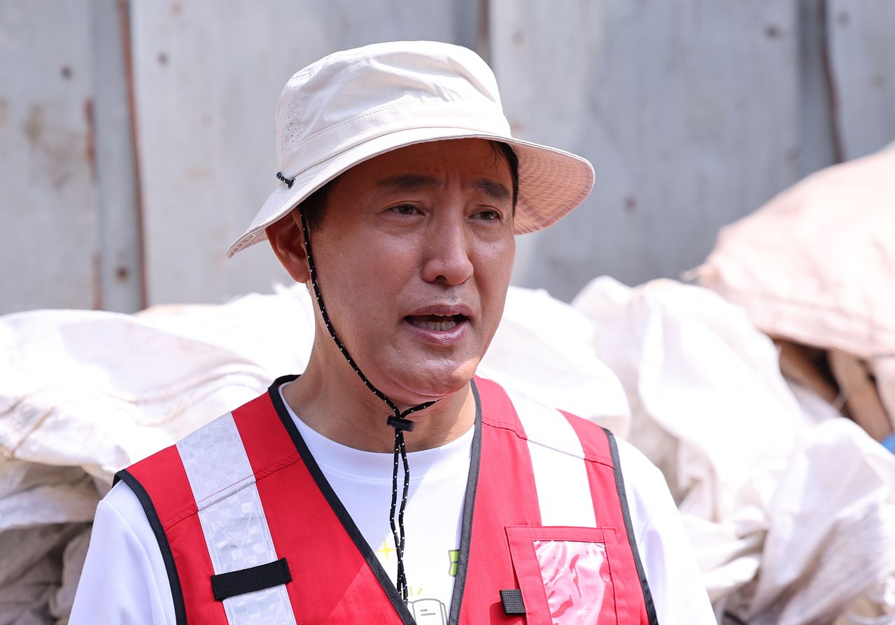 오세훈 서울시장이 4일 서울 용산구 효창동 일대 골목에서 폐지를 수집하는 노인들의 건강상태를 살핀 뒤 핵심 메시지를 전달하고 있다. 뉴스1
