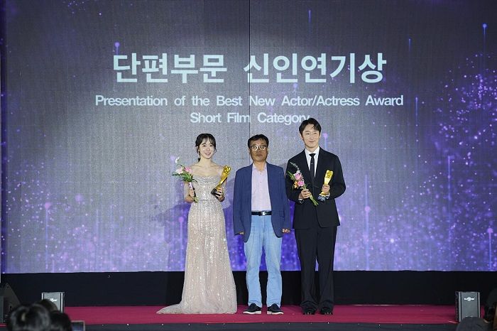 배우 임아영이 트로피와 꽃다발을 받은 뒤 영화 관계자들과 함께 무대에 올랐다. [사진 더흰돌컴퍼니]