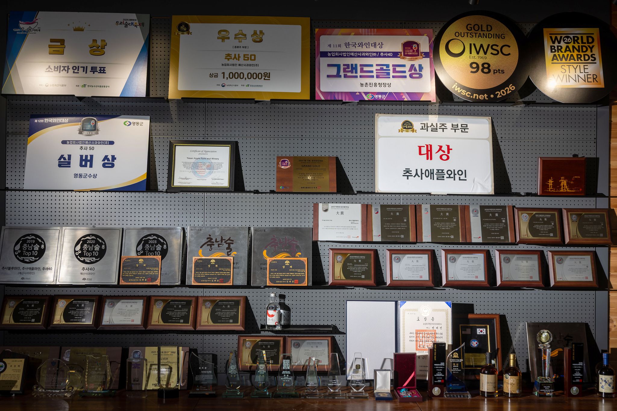 예산사과와인의 국내외 수상 내역들. 최근 '2026 IWSC(국제와인품평회)'에서 98점을 얻어 과실 증류주 부문 최고 등급인 금상과 과실주 부문 최고상을 동시에 받았다.