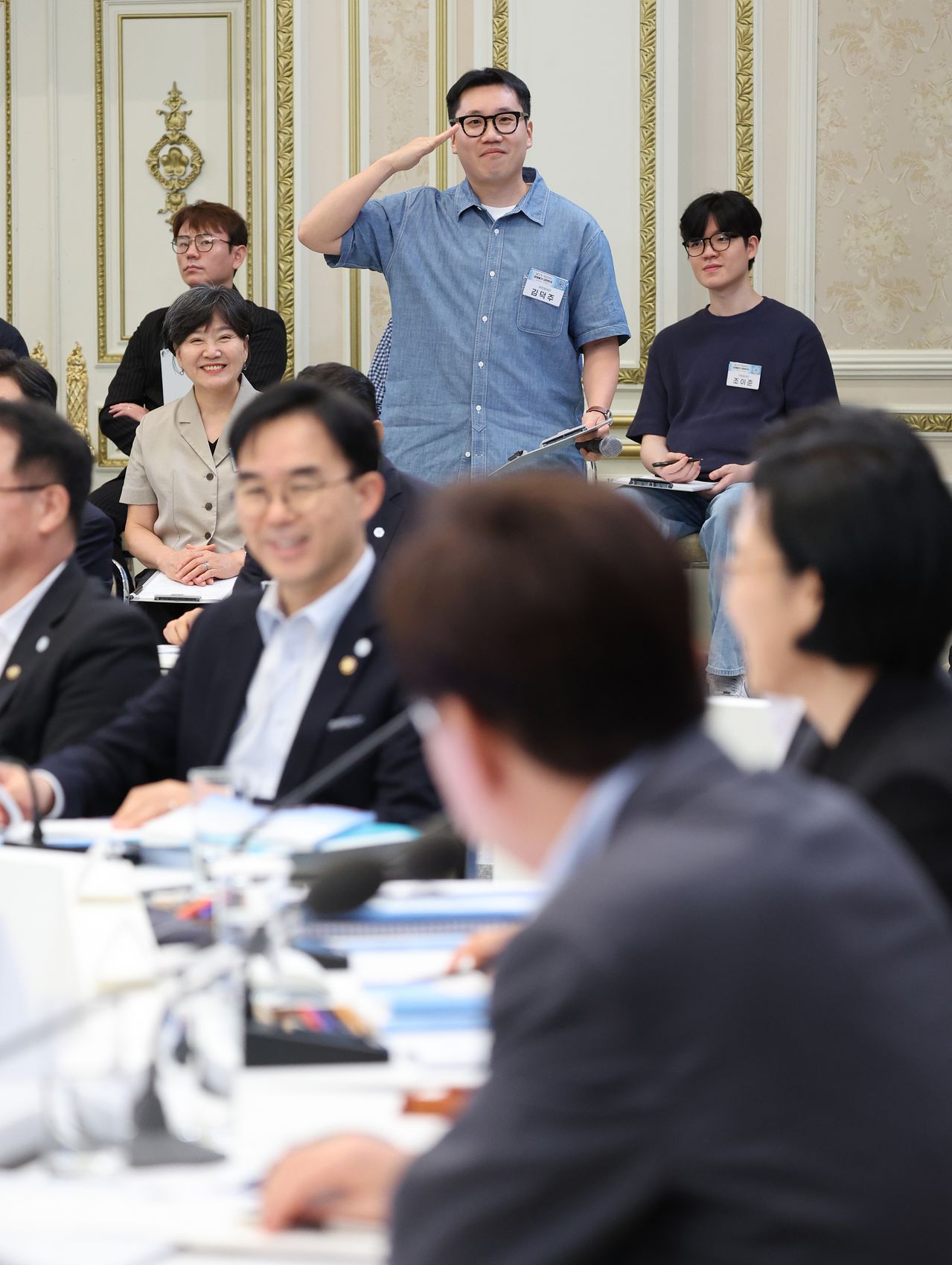 이재명 대통령이 5일 외교부·통일부·국방부·국가보훈부 2차 업무보고에서 거수경례를 하는 국민참여단 참석자를 바라보고 있다. [뉴스1]