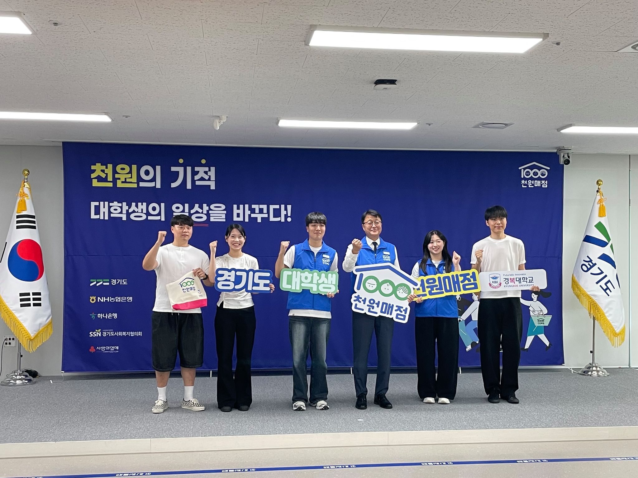 주형철 경기도 경제부지사(왼쪽 네 번째)와 경복대학교 대의원회 학생들이 ‘대학생 천원매점’ 상생 협약식을 마친 후 '경기도' '대학생' '천원매점' 등 공식 팻말과 경복대학교 공식 로고 보드를 들어 올리고 있다. [사진 경복대]