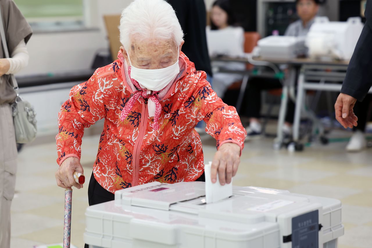 전국동시지방선거 사전투표 첫날인 5월 29일 광주 북구 일곡동 사전투표소에서 104세 어르신이 사전투표를 마치고 손주의 도움을 받아 투표함으로 향하고 있다. 뉴스1