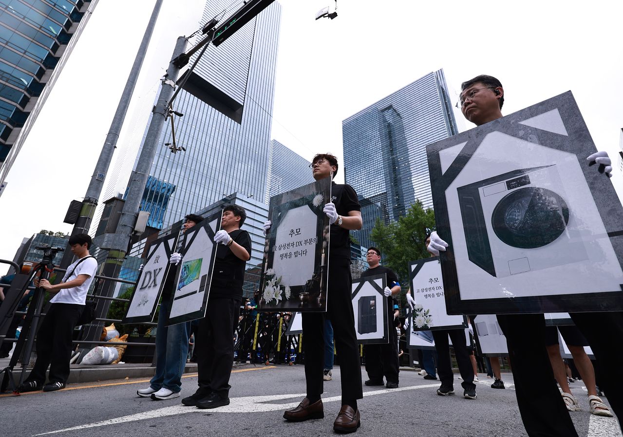 이날 동행노조 조합원들은 세탁기 등 가전제품 사진에 검은 띠를 두른 영정사진 형태의 피켓을 들고 거리를 행진했다. 피켓에는 ‘추모 삼성전자 DX부문, 삼가 명복을 빕니다’라는 문구 등이 적혔다. 뉴스1