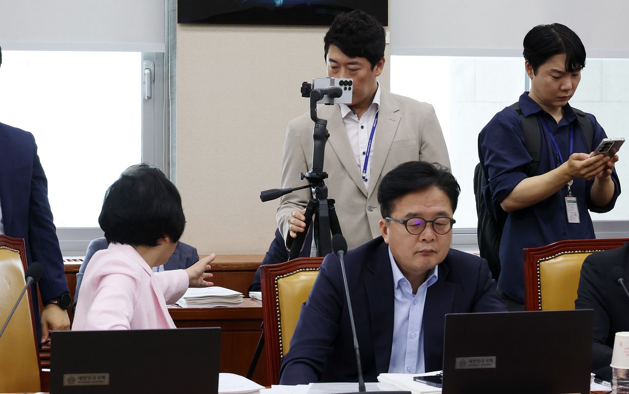 지난 19일 국회에서 열린 과방위 전체회의에서 이진숙 국민의힘 의원실 소속 보좌진이 삼각대를 연결해 이 의원을 촬영하고 있다. 김현 더불어민주당 의원은 의정활동에 방해가 된다며 이 의원실 보좌진에게 이동을 요구했다. 연합뉴스