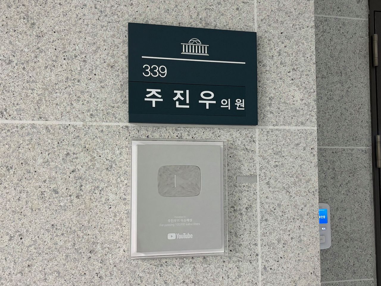 주진우 국민의힘 의원실 앞엔 유튜브 채널 ‘주진우의 이슈해설’의 실버버튼을 걸려있다. 주 의원은 지난해 실버버튼을 받은 후 쭉 실버버튼을 걸어뒀다. 류효림 기자