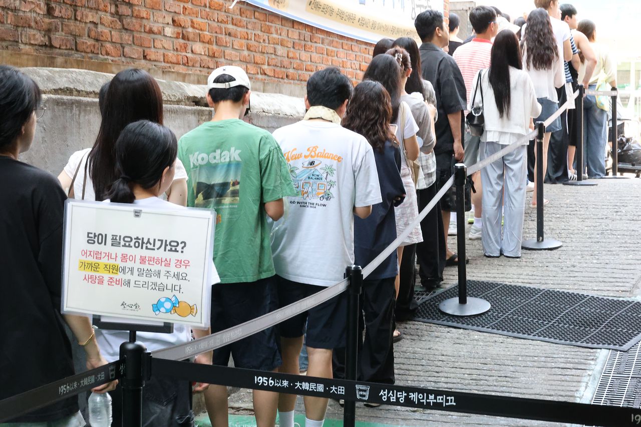 대전 중구 성심당 매장 앞 대기 줄 북적이는 가운데 사탕 제공 안내판이 설치돼 있다. 연합뉴스
