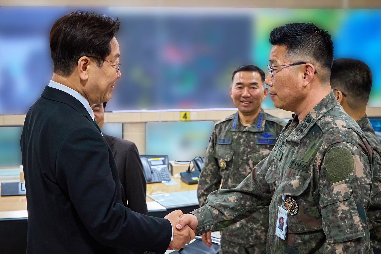 이재명 대통령이 지난 3월 서울 용산 국방부에서 전군주요지휘관회의를 마친 뒤 지휘통제실을 찾아 조성현 대령을 격려하며 악수하고 있다.   12·3 비상계엄 당시 수도방위사령부 제1경비단장이었던 조성현 대령은 국회로 출동하는 병력에 '서강대교를 넘지 말라'고 지시해 불법 계엄을 막는 데 일조한 공로를 인정받아 보국훈장을 받았다. 연합뉴스