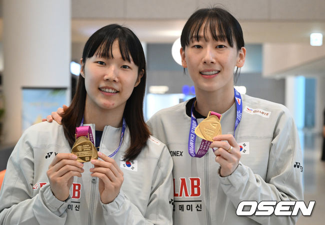 [OSEN=인천공항, 조은정 기자]2026 세계배드민턴연맹(BWF) 세계선수권대회를 마친 대한민국 배드민턴 대표팀이 25일 인천국제공항을 통해 귀국했다.대표팀은 세계선수권대회에서 금메달 2개와 동메달 1개를 수확하며 종합 1위에 올랐다. 여자 복식에서 금메달을 따낸 이소희(오른쪽)와 백하나가 금메달을 들고 포즈를 취하고 있다. 2026.08.25 /cej@osen.co.kr