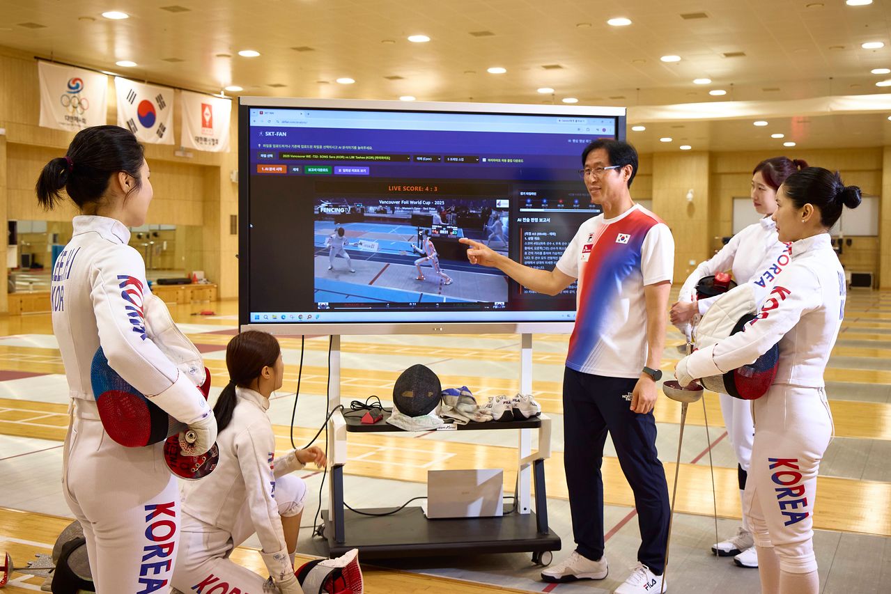 펜싱 에페 여자 국가대표팀 선수들과 함재만 코치가 인공지능(AI) 전력 분석 시스템 SKT-FAN을 활용하는 모습. 사진 SK텔레콤