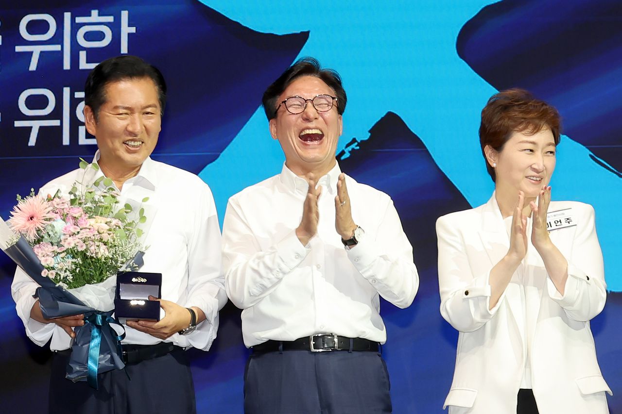 김민석 대표가 27일 인천의 한 호텔에서 열린 ‘2026 정기국회 대비 더불어민주당 국회의원 워크숍’에서 전임 대표였던 정청래 의원(왼쪽)에게 감사패를 전달한 뒤 기념촬영하며 웃고 있다. 오른쪽은 이언주 의원. 장진영 기자
