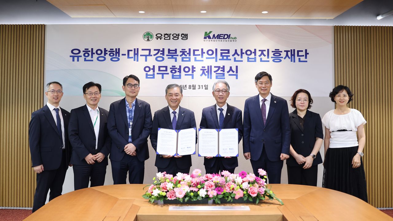 김열홍 유한양행 R&D총괄사장(왼쪽 넷째)과 박구선 케이메디허브 이사장(왼쪽 다섯째)을 비롯한 양 기관 관계자들이 8월 31일 유한양행 본사에서 체결한 협약서를 들어 보이고 있다.