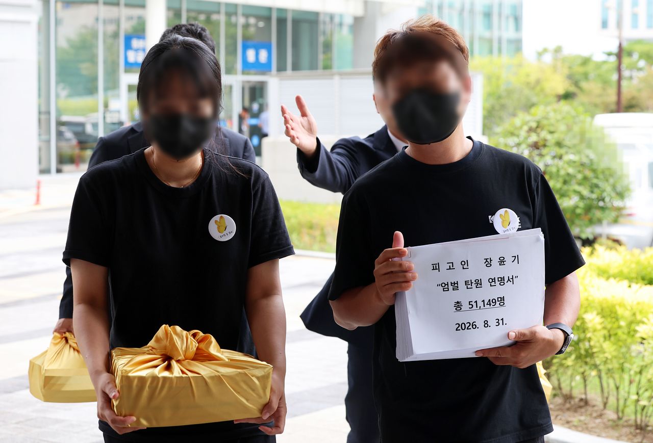 '여고생 살해범' 장윤기의 결심 공판이 열린 31일 광주지방법원에서 이채원양 부모가 엄벌 탄원서를 들고 민원실로 향하고 있다. 연합뉴스