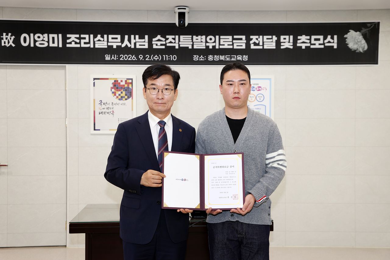 윤건영 충북교육감(왼쪽)은 2일 고 이영미 조리실무사의 아들 황덕규씨에게 순직특별위로금을 전달했다. 사진 충북교육청
