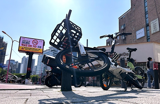 서울 마포구 어울마당로 '홍대 레드로드'에 개인형 이동장치가 보행자들의 통행을 가로막은 채 넘어져있다. 전광판에는 마포구청이 이 곳을 '킥보드 없는 거리'로 지정했다는 안내문을 송출하고 있다. 문희철 기자