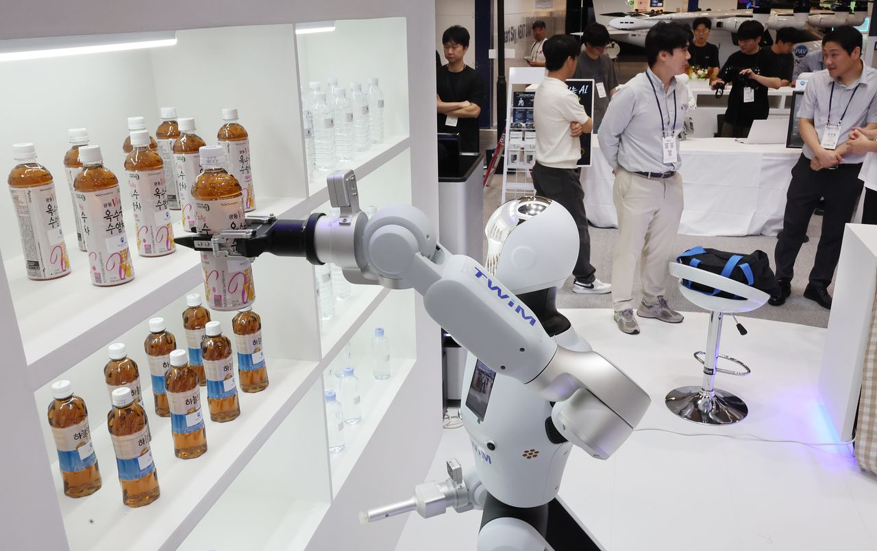  부산 해운대구 벡스코 제1전시장에서 열린 '2026 월드 스마트시티 엑스포' 스마트시티부산 부스에서 AI 휴머노이드 서비스 로봇이 참가자들에게 줄 물을 집고 있다. 연합뉴스