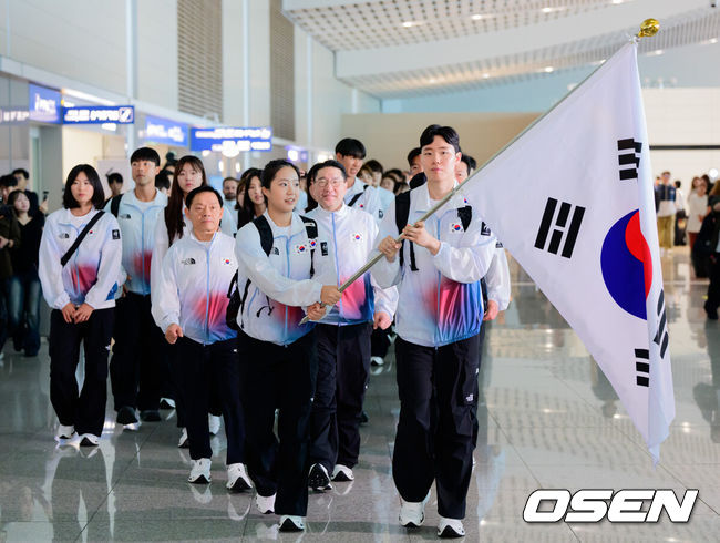 [OSEN=지형준 기자] 2026 아이치-나고야 아시안게임 대한민국 선수단 본단이 17일 오전 인천국제공항을 통해 일본으로 출국했다.아이치-나고야 아시안게임은 19일부터 10월 4일까지 일본 아이치현과 나고야시 일원에서 열린다. 대한민국은 41개 종목에 1,052명의 선수단을 파견한다. 선수 대표 탁구 신유빈, 배드민턴 서승재가 태극기를 들고 선수단과 함께 출국장으로 향하고 있다. 2026.09.17 / jpnews@osen.co.kr