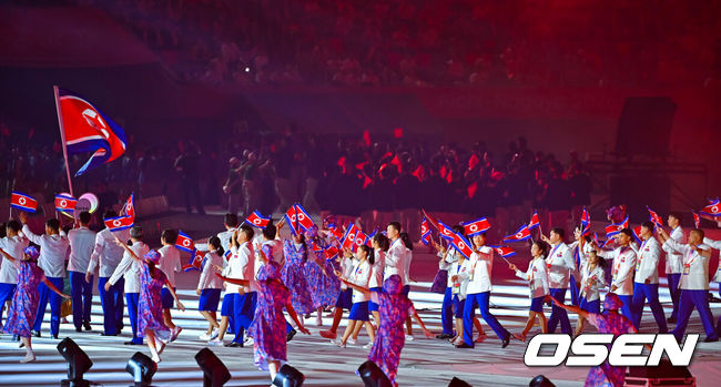 [OSEN=나고야(일본), 박준형 기자] 19일 일본 나고야 미즈호공원 육상경기장에서 제20회 일본 아이치·나고야 아시안게임 개막식이 진행됐다. 아이치·나고야 아시안게임 개회식에서 한국 선수단은 김동용·신유빈을 기수로 9개 종목 50명이 참가해 영문 국가명 순서에 따라 16번째로 입장한다. 아시안게임은 오는 10월 4일까지 열린다. 북한 선수단이 입장하고 있다.  2026.09.19 / soul1014@osen.co.kr