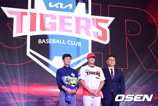 [OSEN=최규한 기자] 21일 오후 서울 잠실동 롯데호텔 월드 크리스탈볼룸에서 ‘2027 KBO 신인드래프트’가 열렸다.이번 신인드래프트는 2025시즌 순위의 역순에 따라 키움 히어로즈, 두산 베어스, KIA 타이거즈, 롯데 자이언츠, KT 위즈, NC 다이노스, 삼성 라이온즈, SSG 랜더스, 한화 이글스, LG 트윈스 순서로 1라운드부터 11라운드까지 지명할 수 있다.경남고 이호민이 전체 3번으로 KIA 타이거즈에 지명된 뒤 심재학 단장과 기념촬영을 하고 있다. 2026.09.21 / dreamer@osen.co.kr