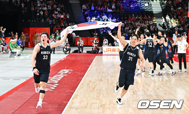 [OSEN=나고야(일본), 박준형 기자] 대한민국 남자농구대표팀이 개최국 일본을 꺾고 12년 만에 아시아 정상으로 돌아왔다. 아시안게임 남자농구 역사상 처음 열린 결승 한일전의 승자는 한국이었다.니콜라스 마줄스 감독이 이끄는 한국은 20일 일본 나고야 IG 아레나에서 열린 2026 아이치·나고야 아시안게임 남자농구 결승에서 일본을 65-57로 제압했다.금메달 확정 후 이승현과 장재석이 태극기를 휘날리며 기뻐하고 있다.  2026.09.20 / soul1014@osen.co.kr