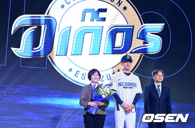[OSEN=최규한 기자] 21일 오후 서울 잠실동 롯데호텔 월드 크리스탈볼룸에서 ‘2027 KBO 신인드래프트’가 열렸다.이번 신인드래프트는 2025시즌 순위의 역순에 따라 키움 히어로즈, 두산 베어스, KIA 타이거즈, 롯데 자이언츠, KT 위즈, NC 다이노스, 삼성 라이온즈, SSG 랜더스, 한화 이글스, LG 트윈스 순서로 1라운드부터 11라운드까지 지명할 수 있다.경남고 박보승이 NC  1라운드에 지명된 뒤 임선남 단장과 기념촬영을 하고 있다. 2026.09.21 / dreamer@osen.co.kr