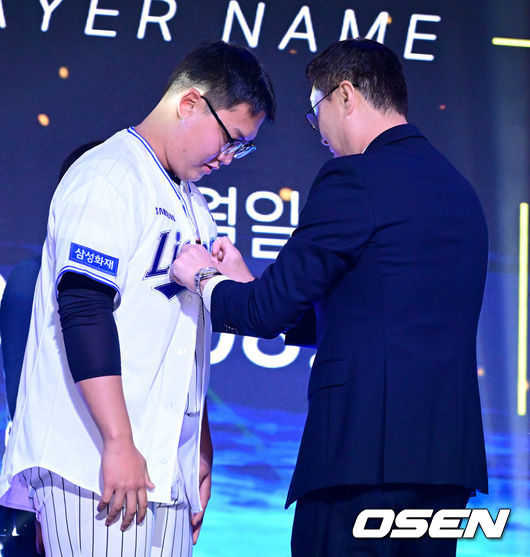 [OSEN=최규한 기자] 21일 오후 서울 잠실동 롯데호텔 월드 크리스탈볼룸에서 ‘2027 KBO 신인드래프트’가 열렸다.이번 신인드래프트는 2025시즌 순위의 역순에 따라 키움 히어로즈, 두산 베어스, KIA 타이거즈, 롯데 자이언츠, KT 위즈, NC 다이노스, 삼성 라이온즈, SSG 랜더스, 한화 이글스, LG 트윈스 순서로 1라운드부터 11라운드까지 지명할 수 있다.광주진흥고 김민훈이 삼성 1라운드에 지명된 뒤 이종열 단장과 기념촬영을 하고 있다. 2026.09.21 / dreamer@osen.co.kr