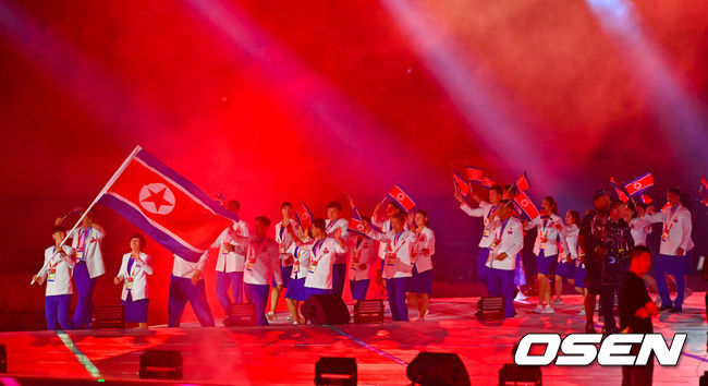 [OSEN=나고야(일본), 박준형 기자] 19일 일본 나고야 미즈호공원 육상경기장에서 제20회 일본 아이치·나고야 아시안게임 개막식이 진행됐다. 아이치·나고야 아시안게임 개회식에서 한국 선수단은 김동용·신유빈을 기수로 9개 종목 50명이 참가해 영문 국가명 순서에 따라 16번째로 입장한다. 아시안게임은 오는 10월 4일까지 열린다. 북한 선수단이 입장하고 있다.  2026.09.19 / soul1014@osen.co.kr