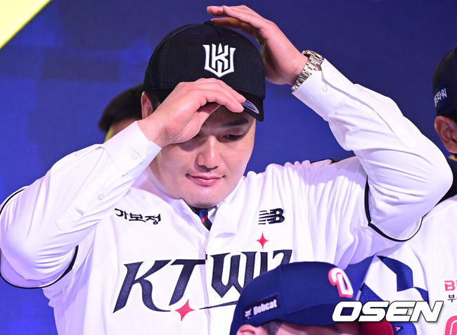 [OSEN=최규한 기자] 21일 오후 서울 잠실동 롯데호텔 월드 크리스탈볼룸에서 ‘2027 KBO 신인드래프트’가 열렸다.이번 신인드래프트는 2025시즌 순위의 역순에 따라 키움 히어로즈, 두산 베어스, KIA 타이거즈, 롯데 자이언츠, KT 위즈, NC 다이노스, 삼성 라이온즈, SSG 랜더스, 한화 이글스, LG 트윈스 순서로 1라운드부터 11라운드까지 지명할 수 있다.최지만이 전제 15순위로 KT 위즈에 지명된 뒤 기념촬영을 준비하고 있다. 2026.09.21 / dreamer@osen.co.kr