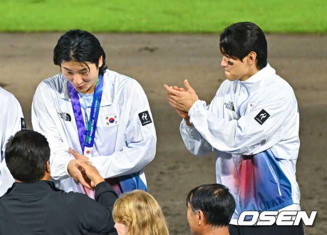 [OSEN=도요하시(일본), 박준형 기자] 한국야구가 우여곡절 끝 아시안게임 5회 연속 금메달을 해냈다.류지현 감독이 이끄는 한국 야구대표팀은 27일 일본 아이치현 도요하시 시민구장에서 열린 2026 아이치-나고야 아시안게임 일본과 결승전에서 3-1로 승리했다. 시상식에서 김도영이 곽빈에게 박수를 치고 있다    2026.09.27 / soul1014@osen.co.kr