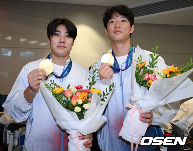 [OSEN=인천공항, 조은정 기자]2026 아이치·나고야 아시안게임에서 금메달을 차지한 야구 대표팀이 28일 인천국제공항을 통해 귀국했다.한국 야구 대표팀은 금메달을 따내며 2010년 광저우 대회를 시작으로 2014년 인천, 2018년 자카르타-팔렘방, 2023년 항저우, 2026년 나고야-아이치까지 아시안게임 5회 연속 우승을 달성했다.야구대표팀 박준순, 최민석이 금메달을 들고 포즈를 취하고 있다. 2026.09.28 /cej@osen.co.kr
