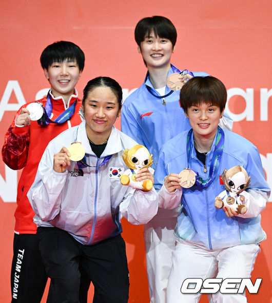 [OSEN=아이치현(일본), 박준형 기자] 또 하나의 배드민턴 역사가 탄생했다.'셔틀콕 여제' 안세영(24, 삼성생명)이 최초의 아시안게임 여자 단식 2연패라는 대업을 이뤘다.안세영은 29일 일본 이치노미야 시립 체육관에서 열린2026년 아이치·나고야 아시안게임 배드민턴 여자 단식 결승전에서 야마구치 아카네(일본·세계 3위)를 2-0(21-17 21-9)로 격파하고 금메달을 차지했다. 결승전마저 휴식시간 총 52분 만에 2-0 완승으로 끝내며 '퍼펙트 우승'을 완성했다.시상식에서 안세영이 야마구치, 천위페이, 왕즈이와 포즈를 취하고 있다.   2026.09.29 / soul1014@osen.co.kr