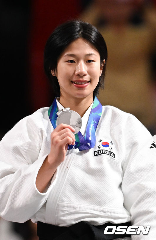 [OSEN=나고야(일본), 박준형 기자] 장세윤이 골든스코어 끝에 한국 유도 첫 메달을 땄다.장세윤은 30일 일본 나고야 아이치 인터내셔널 아레나에서 열린 2026년 아이치·나고야 아시안게임 유도 여자 52㎏급 결승에서 시타 카담보예바(우즈베키스탄)에 연장 끝에 세번째 지도를 받으며 반칙패로 졌다.시상식 은메달 리스트 장세윤이 포즈를 취하고 있다. 2026.09.30 /  soul1014@osen.co.kr