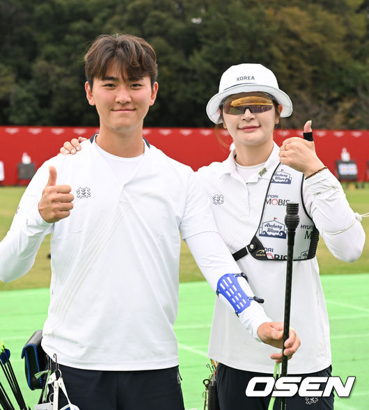 [OSEN=아이치현(일본), 박준형 기자]  27일 일본 아이치현 오카자키 중앙종합공원 다목적광장에서 '2026 아이치·나고야 아시안게임' 양궁 리커브 남녀혼성 8강전이 진행됐다.랭킹 라운드에서 아시안게임 신기록을 잇달아 작성한 양궁대표팀은 리커브의 강세를 이어가는 동시에 3년 전 항저우에서 인도에 내줬던 컴파운드 정상 탈환까지 노린다.4강행 확정한 리커브 김제덕과 강채영이 포즈를 취하고 있다.   2026.09.27 / soul1014@osen.co.kr