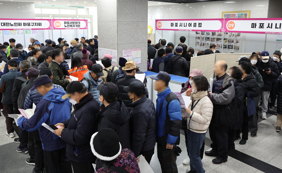 지난해 12월 서울 마포구청에서 열린 마포구 노인일자리 박람회를 찾은 시민들이 일자리 신청을 위해 줄을 서 있다. 연합뉴스