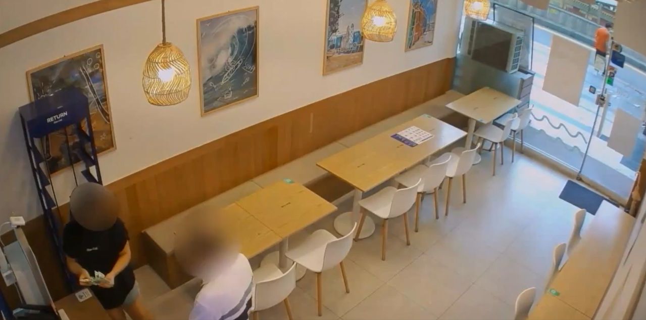 상습 사기범 A씨(오른쪽)가 한 음식점에서 단체 예약을 빙자해 돈을 빌려달라고 한 뒤 업주로부터 현금을 건네받고 있다. 사진 의정부경찰서
