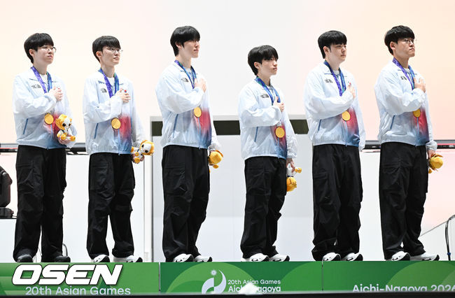 [OSEN=도코나메(일본), 박준형 기자] 1, 2세트의 아슬아슬했던 위기를 연속 대역전극으로 이겨낸 대한민국 e스포츠 대표팀이 대만을 완전히 압도하며 금메달을 차지햇다. 강동훈 감독이 이끄는 대한민국 대표팀은 2일 일본 아이치현 도코나메시 아이치 스카이 엑스포에서 열린 2026 아이치·나고야 아시안게임 e스포츠 LoL 결승전 대만과의 3세트 경기에서 시작부터 상체와 정글 주도권을 단단히 움켜쥐며 대만을 압박한 끝에 29분 만에 넥서스를 깨뜨리고 금메달을 확정 지었다.시상식에서 LoL 한국대표팀이 국민의례를 하고 있다.   2026.10.02 /  soul1014@osen.co.kr