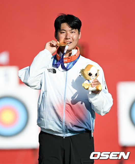 [OSEN=오카자키(일본), 박준형 기자]'한국 양궁의 마지막 희망' 이우석(29, 코오롱)이 마침내생애 첫 아시안게임 개인전 금메달을 획득했다. 일본의 중심부에서 일본 선수를 꺾고 태극기를 휘날렸다.이우석은3일오카자키 중앙공원 다목적 광장에서 열린 2026 아이치·나고야 아시안게임 양궁 리커브 남자 개인전 결승에서 나카니시 준야(일본)를 6-2(29-26, 27-27, 29-29, 29-27)로 누르고 금메달을 목에 걸었다.시상식에서 이우석이 금메달을 들고 포즈를 취하고 있다.   2026.10.03 /  soul1014@osen.co.kr