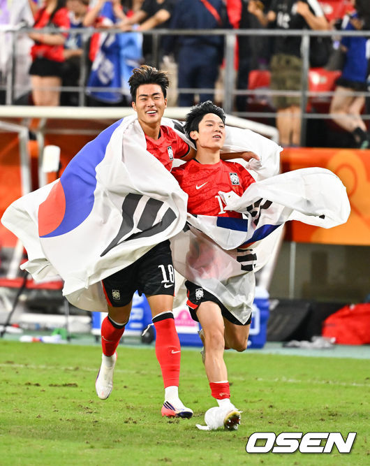 [OSEN=도요타(일본), 박준형 기자] 미쳤다! 엄지성(24, 스완지 시티)이 결승골로 한국축구를 살렸다.이민성 감독이 이끄는 U23 남자축구대표팀은 3일 오후 7시 30분 도요타 스타디움에서 개최된 아이치-나고야 아시안게임 2026 결승전에서 엄지성의 결승골이 터져 숙적 일본을 1-0으로 제압했다.경기종료 후 김명준과 양민혁이 태극기를 들고 그라운드를 돌고 있다.   2026.10.03 /  soul1014@osen.co.kr