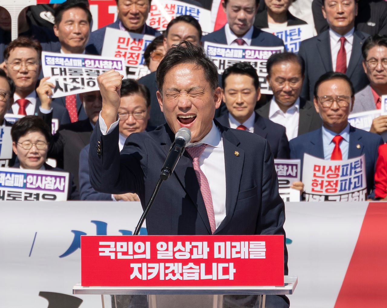 국민의힘 김태규 의원이 22일 국회 본청 앞에서 열린 이재명 정권 실정 대국민 보고대회에서 검찰과 사법 분야 연설을 마친 뒤 이 대통령 재판 재개를 촉구하는 구호를 외치고 있다. 연합뉴스