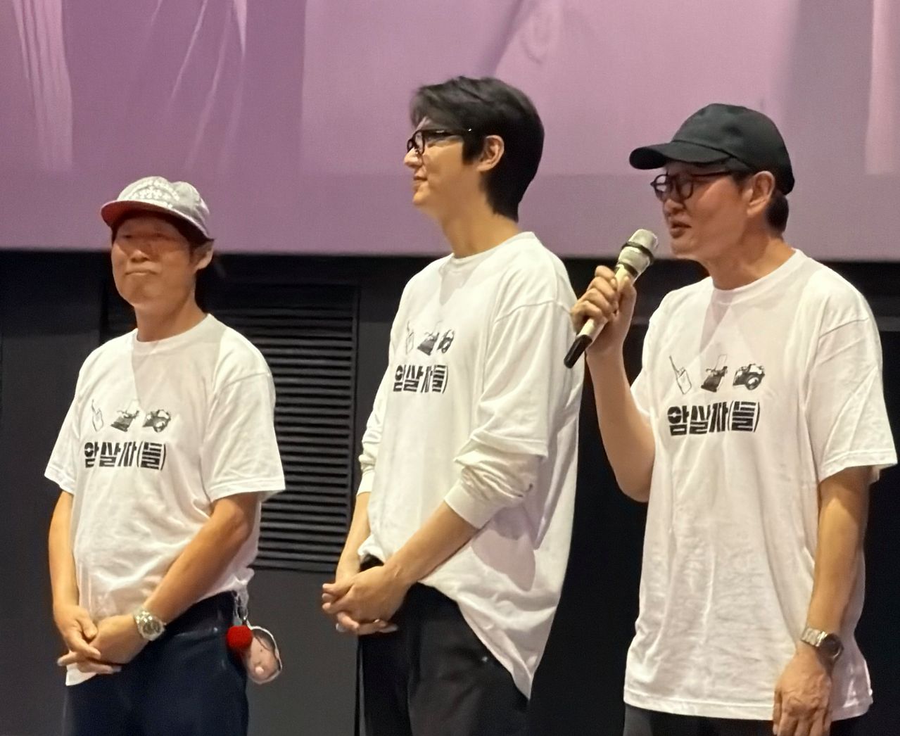 지난달 24일 서울 롯데시네마에서 열린 영화 ‘암살자(들)’무대인사에서 허진호 감독이 관객들에게 인사말을 하고 있다. 왼쪽부터 유해진ㆍ이민호 배우. 사진 독자 포질로바 무니사