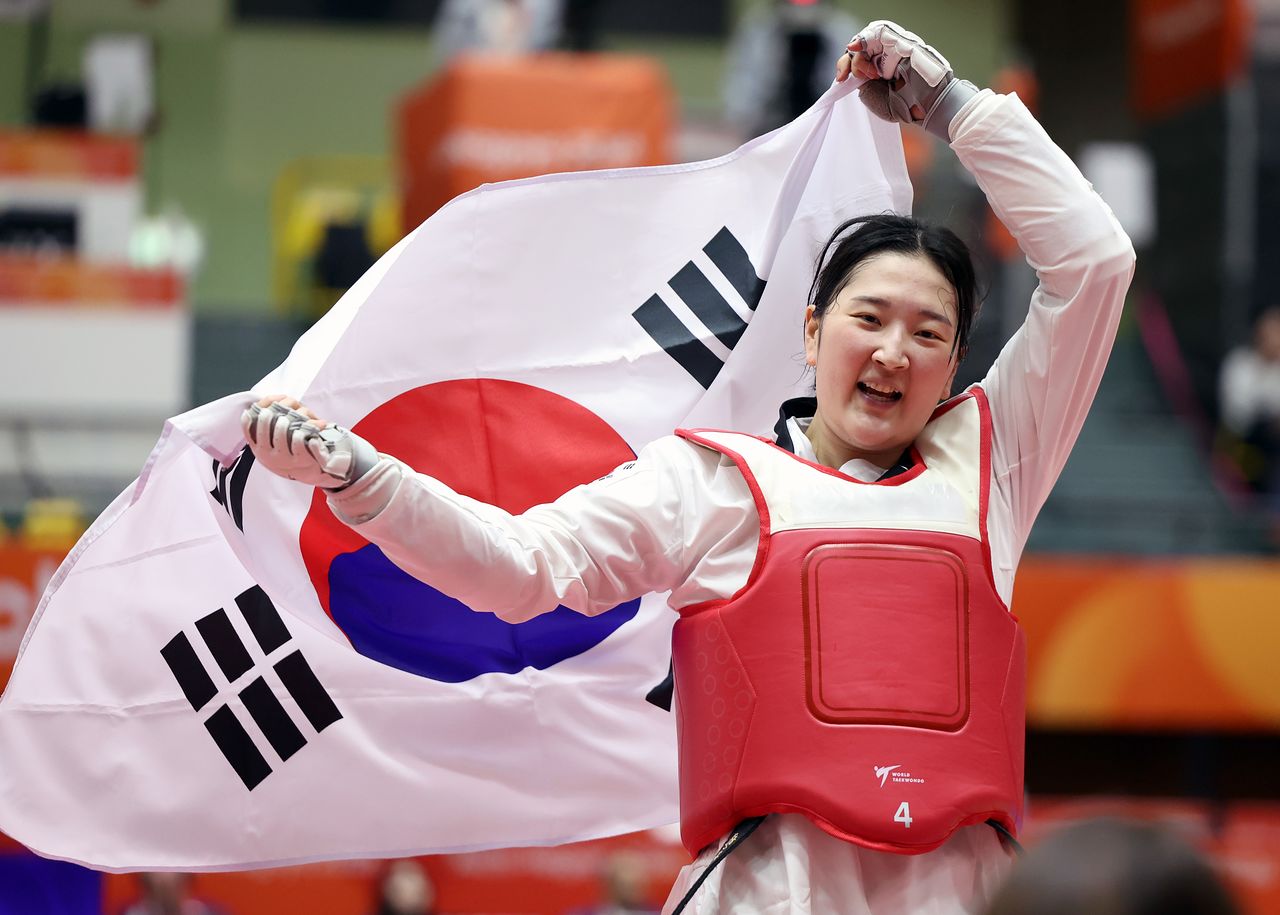 3일 일본 아이치현 도요하시 종합체육관에서 열린 2026 아이치·나고야 아시안게임 태권도 겨루기 여자 67㎏급 한국 송다빈과 중국 무원저 결승 경기. 금메달을 획득한 한국 송다빈이 태극기를 들고 경기장을 돌고 있다. 연합뉴스