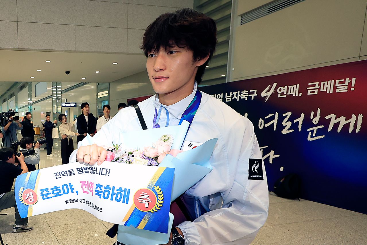 귀국길에 팬이 건넨 ‘전역 축하해’ 문구를 받아든 축구 대표팀 배준호. [뉴스1]