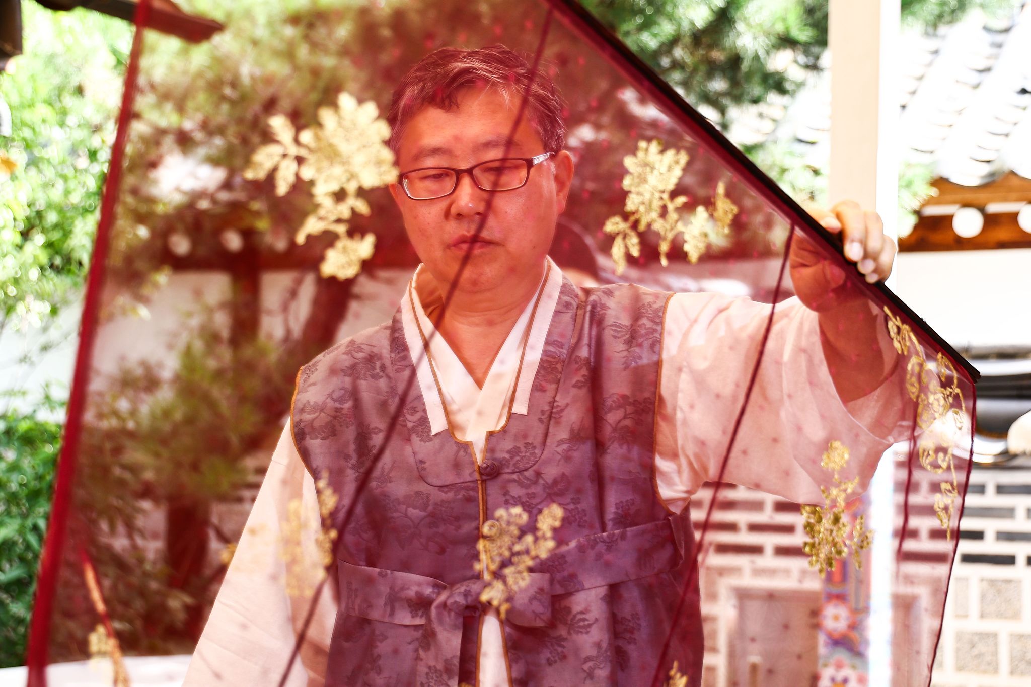김 장인이 비단에 입힌 금박 문양의 상태를 살펴보고 있다.