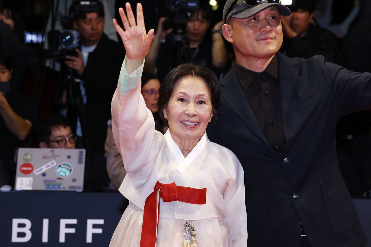  배우 김혜자(왼쪽)가 6일 오후 부산 해운대구 영화의 전당에서 열린 제31회 부산국제영화제(BIFF) 개막식 레드카펫 행사에서 송일곤 감독의 부축을 받으며 들어서고 있다. 연합뉴스