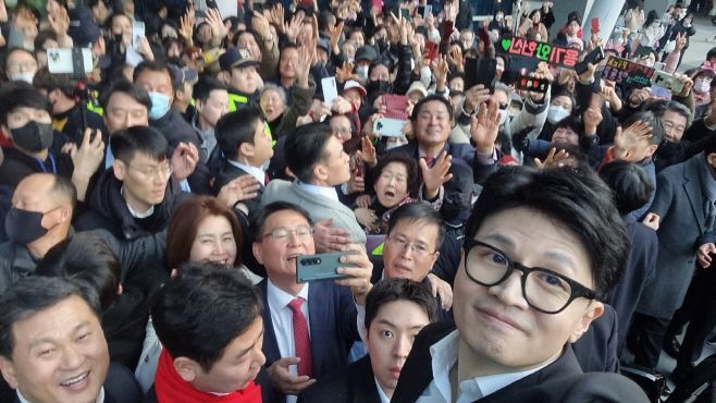 2024년 1월 10일 부산 남포동 비프(BIFF)광장에서 한동훈 국민의힘 비상대책위원장이 의자 위에 올라 시민들과 함께 사진을 찍고 있다. 사진 국민의힘