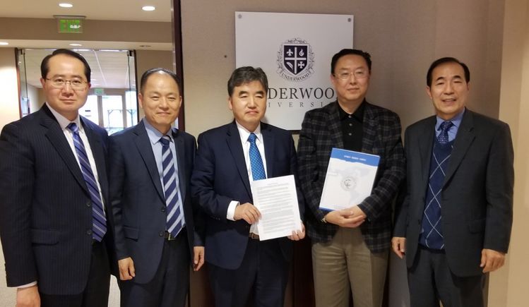 미주성결신학대학교 황하균 총장(가운데)과 언더우드대학교 리처드 윤 총장(왼쪽에서 네 번째)이 양해각서를 들고 함께 서 있다. [사진 미주성결신학대학교]