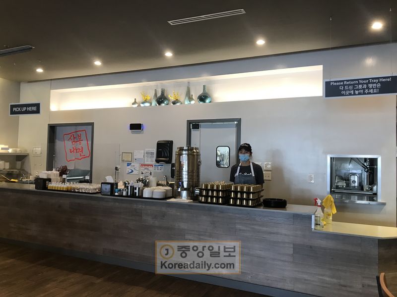 지난 14일 오후 둘루스 삼봉냉면에서 김선미 대표가 셀프 서비스대 앞에 서 있다. 삼봉냉면은 셀프서비스대에 스니즈 가드를 설치했다.