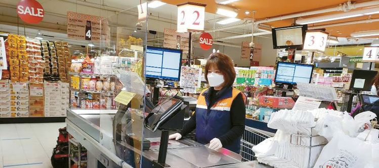 H마트 뉴저지 리치필드 매장 직원이 스니즈 가드가 설치된 계산대에서 고객을 맞을 준비를 하고 있다. [H마트 제공]